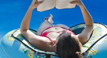 woman reading book in swimmingpool